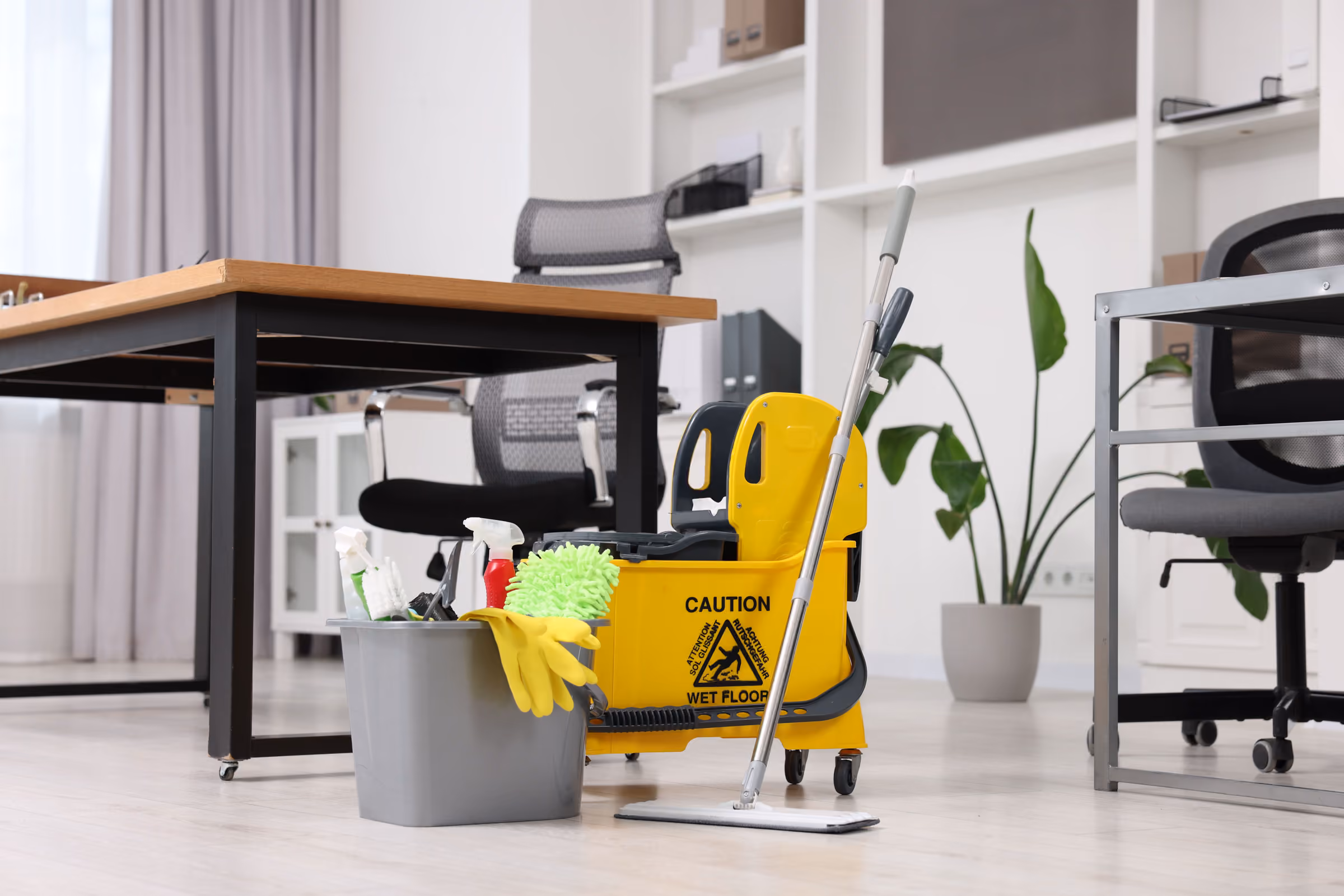 Limpieza de oficinas en Parla Limpieza de oficinas en Parla: carro con cubo, fregona y productos entre las mesas