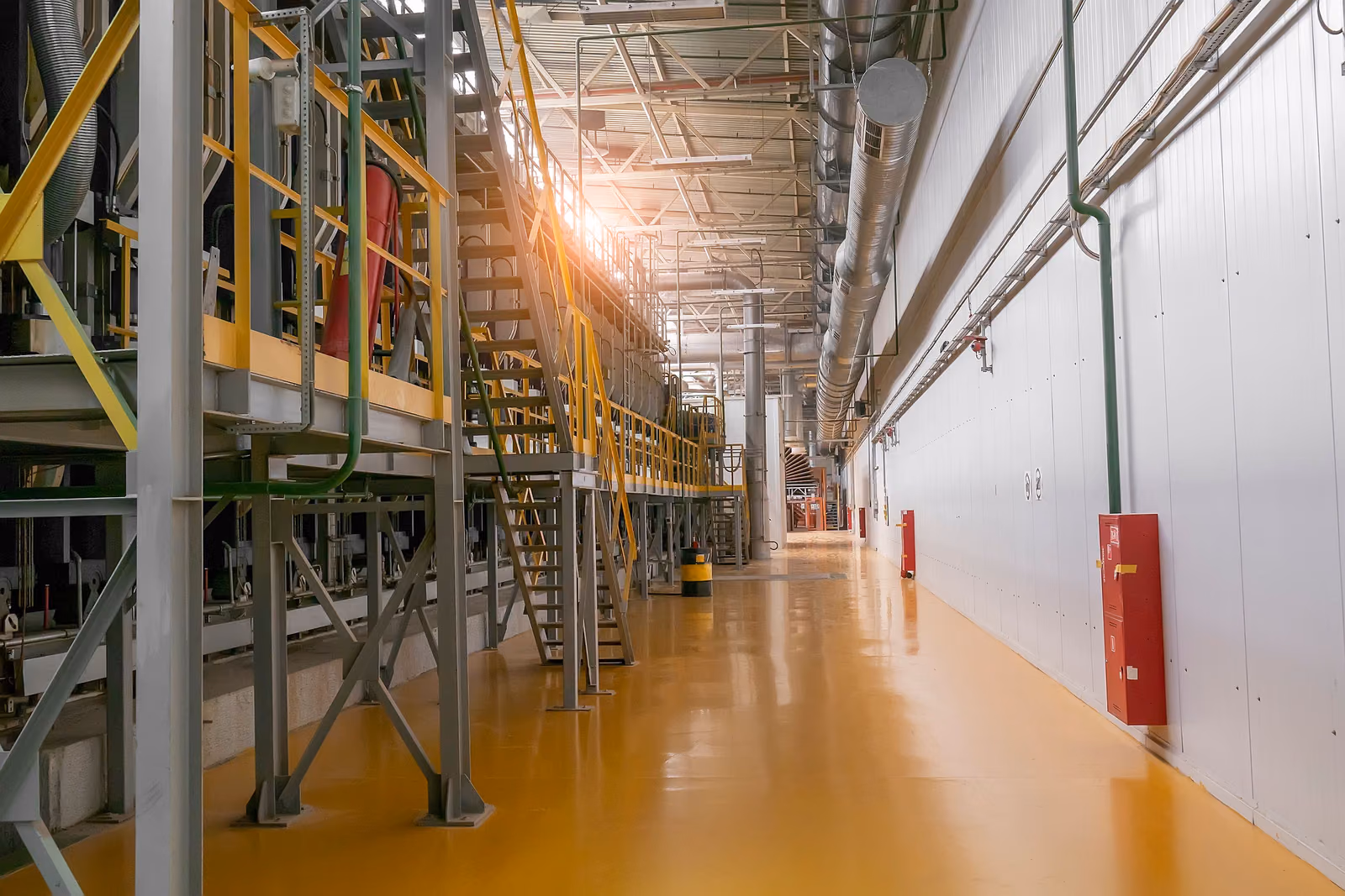 Pasillo de una planta industrial con el suelo amarillo limpio